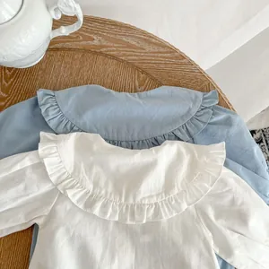 Détail de barboteuses bébé avec cols Claudine à volants en coton blanc et bleu