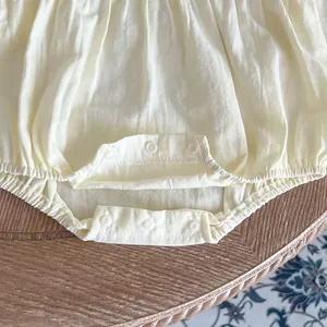 Détail du body pour bébé en coton avec 5 boutons-pression et ouvertures élastiques