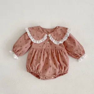 Détail d'un body fleuri pour bébé avec col Peter Pan et bordure en dentelle fine