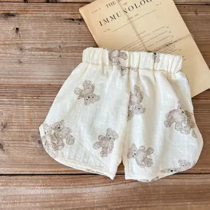 Dettaglio di pantaloncini estivi per neonati in cotone-lino con stampa orso ed elastico