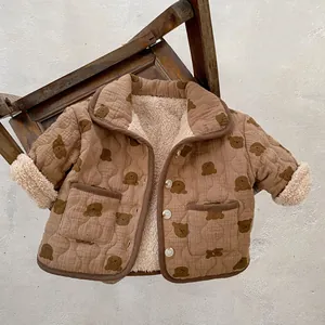 Detail of baby quilted jacket with bear print and soft cream fleece lining inside