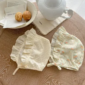 Dettaglio cappelli da sole per neonati con stampe floreali e bordi a balze a pois