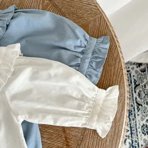 Détail du col volanté et des poignets sur des barboteuses en coton pour bébé fille