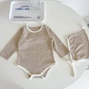 Close-up of baby romper with white polka dots, cotton texture and snap buttons
