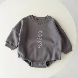 Close-up of baby dinosaur romper with reinforced metal snap buttons for easy diaper changes