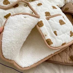 Close-up of baby winter coat showing thick white sherpa lining and bear pattern print