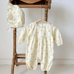Dettaglio body neonato floreale con volant e cappello coordinato stile vintage su gruccia