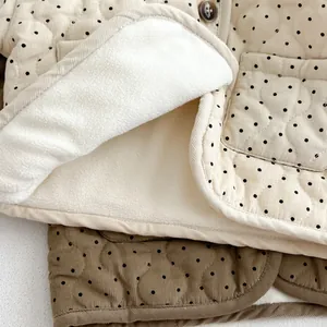 Detail of polka dot corduroy fabric with warm faux fleece lining and textured buttons