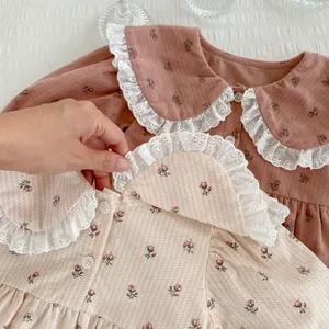 Détail du body floral pour bébé avec col en dentelle et texture de tissu en coton doux