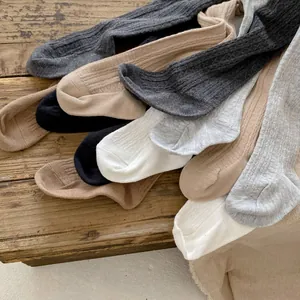 Flat lay of ribbed knit cotton leggings for baby girls in various neutral earth tones