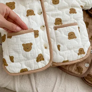 Close-up of quilted baby jacket with bear prints, showing pocket detail and soft fabric