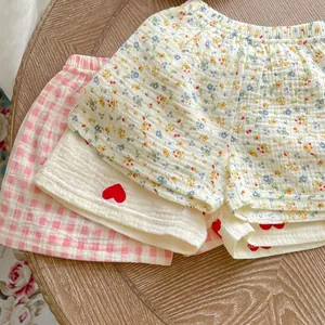 Flat lay of baby cotton gauze shorts featuring floral, heart, and plaid patterns