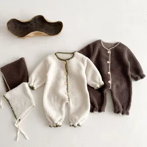 Detail of baby fleece romper with matching hat, featuring retro wooden buttons and lace edges