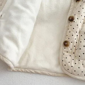 Detail of infant quilted vest with black polka dots and warm faux shearling lining