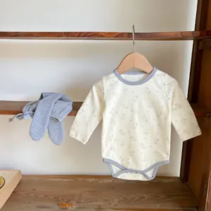 Detailed view of long-sleeve cotton baby bodysuit with bunny print and ribbed gray pants