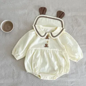 Détail du body bébé avec broderie d'ours, manches bouffantes et bonnet à oreilles assorti
