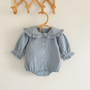 Détail d'un barboteuse bébé avec col Claudine à volants et boutons en couleur bleu poudré