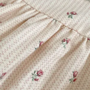 Détail du tissu du body bébé à fleurs avec roses roses et texture en coton plissé
