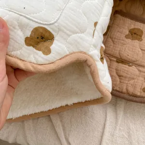 Detail of baby winter jacket with thick sherpa lining and cute brown bear patterns