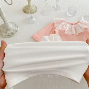Détail du tissu côtelé extensible et du col en dentelle sur ce haut pour enfants