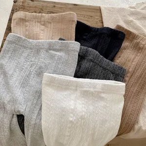 Close-up of ribbed knit texture and cable patterns in various neutral colors for leggings