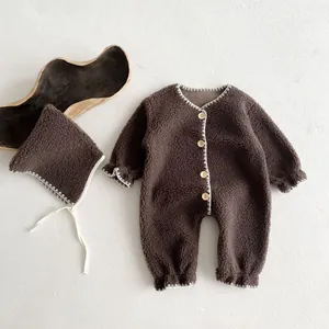 Detail view of baby sherpa romper with wooden buttons and matching hat in dark brown