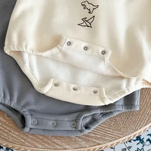 Detail of baby dinosaur onesie showing warm thick fleece lining and metal snap buttons