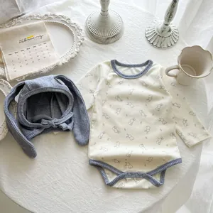 Detail of infant long sleeve cotton bodysuit with rabbit print and matching bunny ear hat
