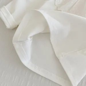 Gros plan du t-shirt bébé à manches longues avec col en dentelle et texture coton doux