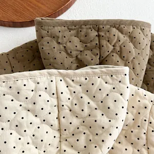 Detail of quilted polka dot corduroy fabric for children's winter jackets and gear