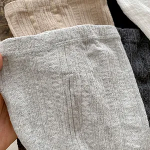 Detail of high-waist elastic waistband on cable-knit leggings for baby girls