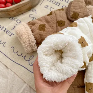 Detail of baby bear print quilted jacket showing thick white fleece lining and soft cuffs