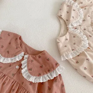 Détail de bodys pour bébé à fleurs avec col en dentelle et texture de coton doux