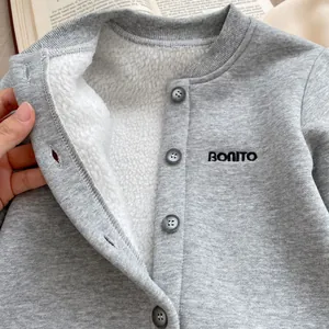 Dettaglio di pagliaccetto per neonati con calda fodera in pile e ricamo Bonito su maglia grigia
