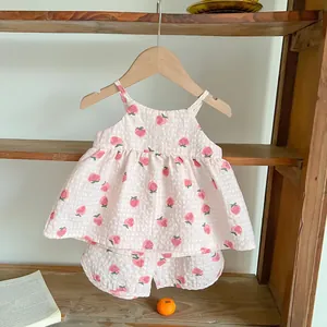 Dettaglio del tessuto seersucker rosa con fragole per set estivo neonato