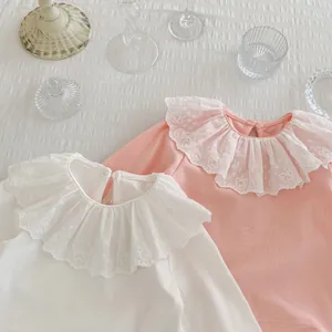 Détail de hauts à manches longues pour bébés avec col en dentelle et broderie d'ours