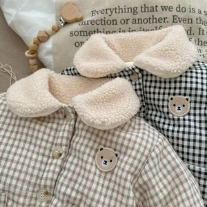 Close-up of baby winter plaid jackets with warm fleece collar and cute bear patch