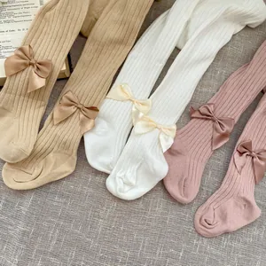 Detail showing knit texture and satin bows on assorted baby girl footed cotton leggings