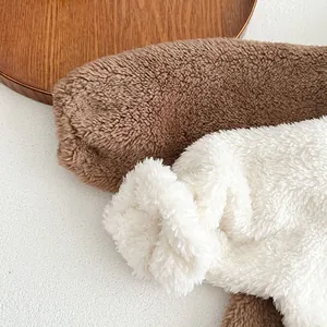 Detailed macro view of soft brown and cream fleece fabric texture for baby clothes