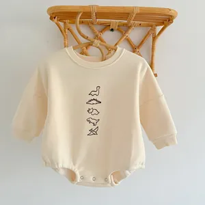 Detailed view of baby dinosaur onesie with soft ribbed collar and metal snap buttons