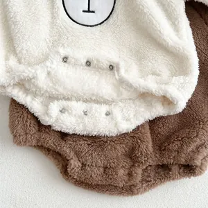 Detail of soft sherpa fleece fabric and bottom metal snap buttons on baby romper