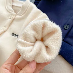Close-up of baby knit cardigan showing thick warm fleece lining and letter embroidery