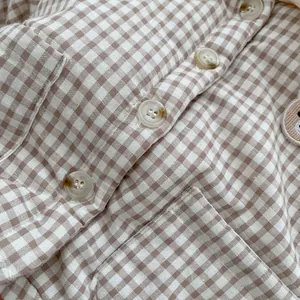 Detailed macro view of brown gingham fabric with white buttons and cute bear embroidery