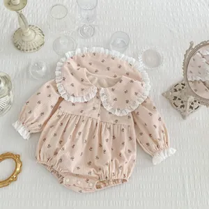 Détail du body bébé à fleurs avec col en dentelle et boutons-pression pratiques
