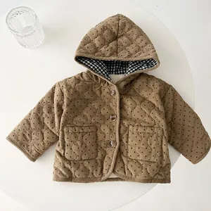 Detail of brown polka dot corduroy quilted jacket with wooden buttons and plaid lining