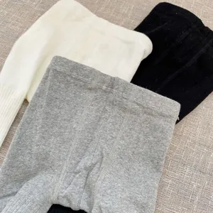 Detailed knit texture and elastic waist of baby ribbed leggings in white grey and black