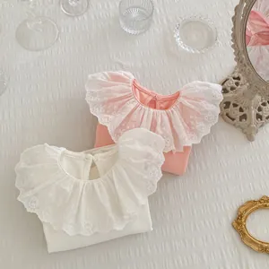 Détail du col en dentelle avec broderie sur un haut en coton côtelé pour bébé