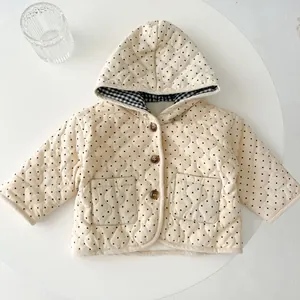 Detailed close-up of baby hooded corduroy jacket with polka dots and heart-shaped quilting