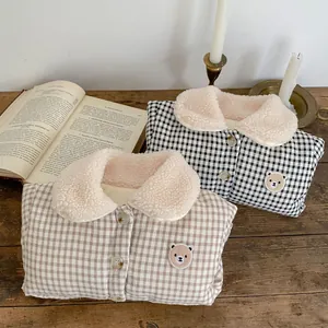 Detail of warm checkered baby winter vest featuring plush fleece collar and bear embroidery