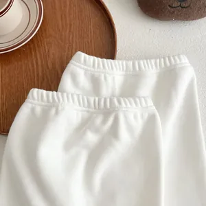Detail of baby warm fleece pants with elastic waistband on a cozy wooden tray